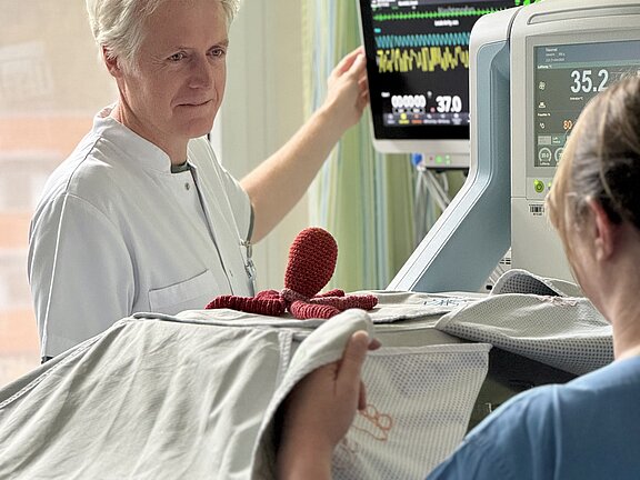 Dr. Hillebrand an einem Frühchenbett mit Monitor