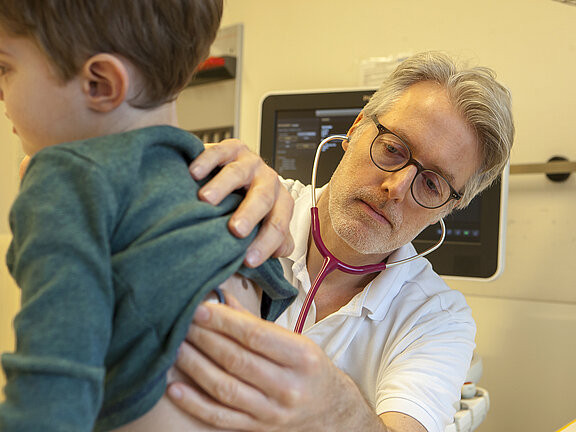 Chefarzt Dr. med. Georg Hillebrand horcht eine Patienten mit dem Stetoskop ab.