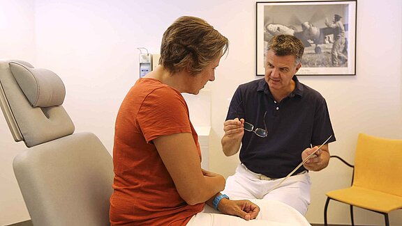 Mund-Kiefer-Gesichtschirurg Dr. Dr. Alexander Tschakaloff im Gespräch mit einer Patientin