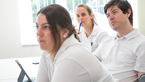 MedizinerInnen hören bei einer Fachveranstaltung interessiert zu.