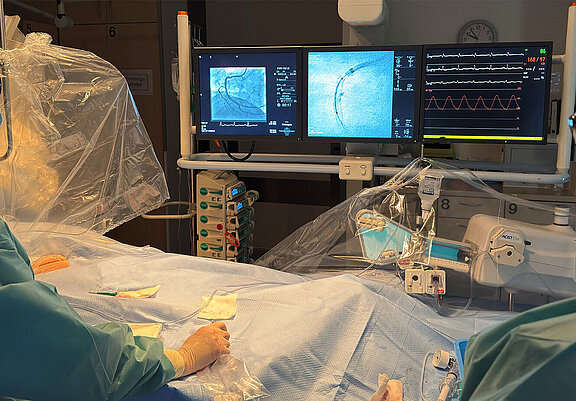 Zwei Mediziner schauen während einer Herzkatheteruntersuchung auf die Monitore.