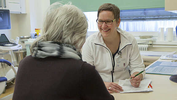 Beratungssituation im Behandlungszimmer, Oberärztin Dr. Birte Zeigert lächelt die Patientin an.