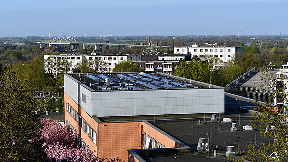Blick vom Hubschrauberlandeplatz in Richtung Süd-Westen: Auf dem Dach des Ärzte- und Dienstleistungszentrums des Klinikums Itzehoe eine Photovoltaikanlage, im Hintergrund die Störbrücke der A23 und Blick über die Wilstermarsch.